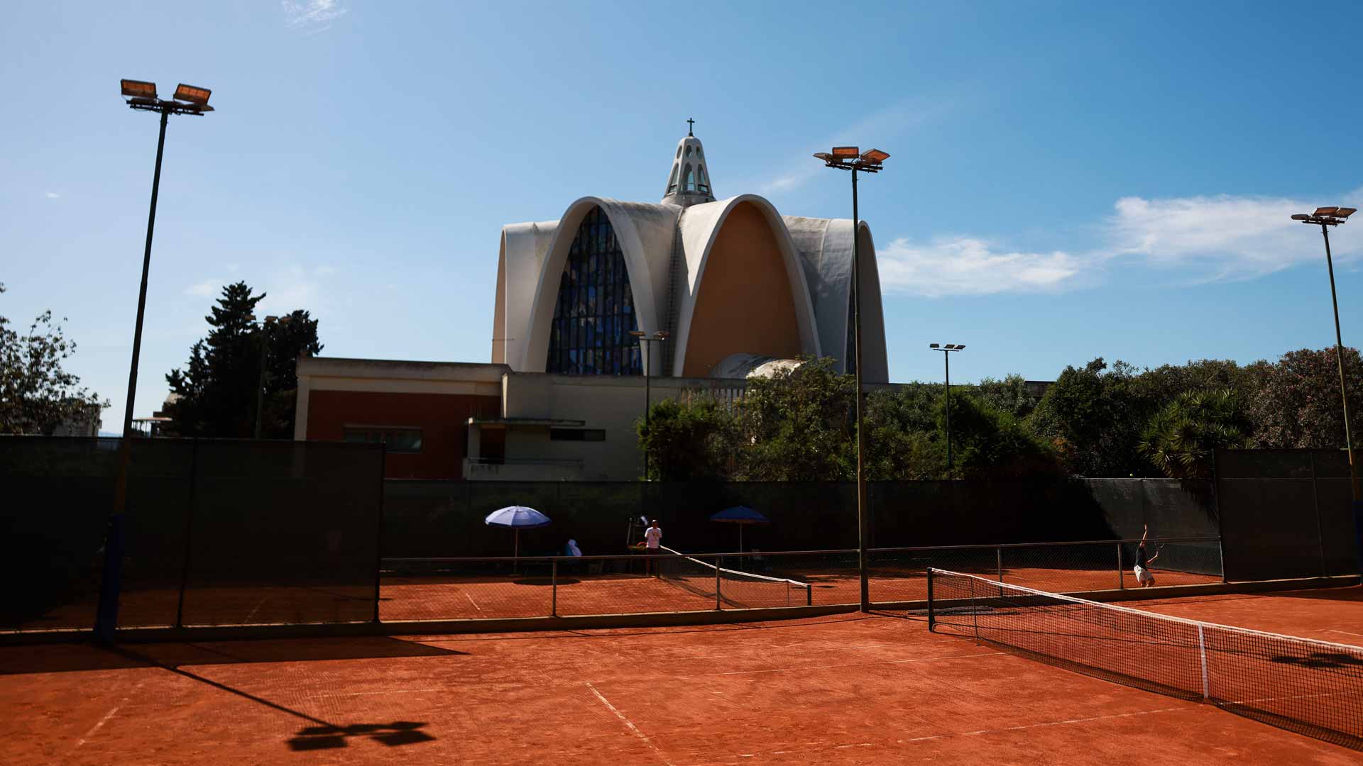 The Sardegna Open is played at the Tennis Club Cagliari, with Chiesa dei Santi Giorgio e Caterina in the background.