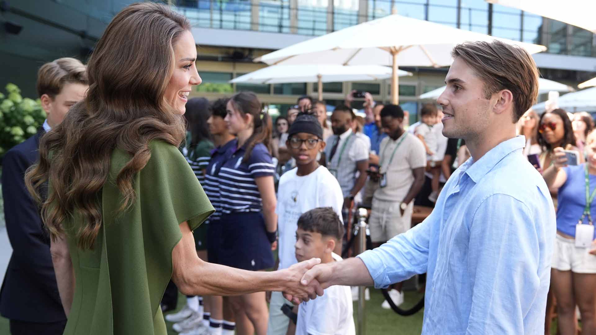 Catherine, Princess of Wales, also known as Kate Middleton, shakes hands with Arthur Fery Sunday at Wimbledon.